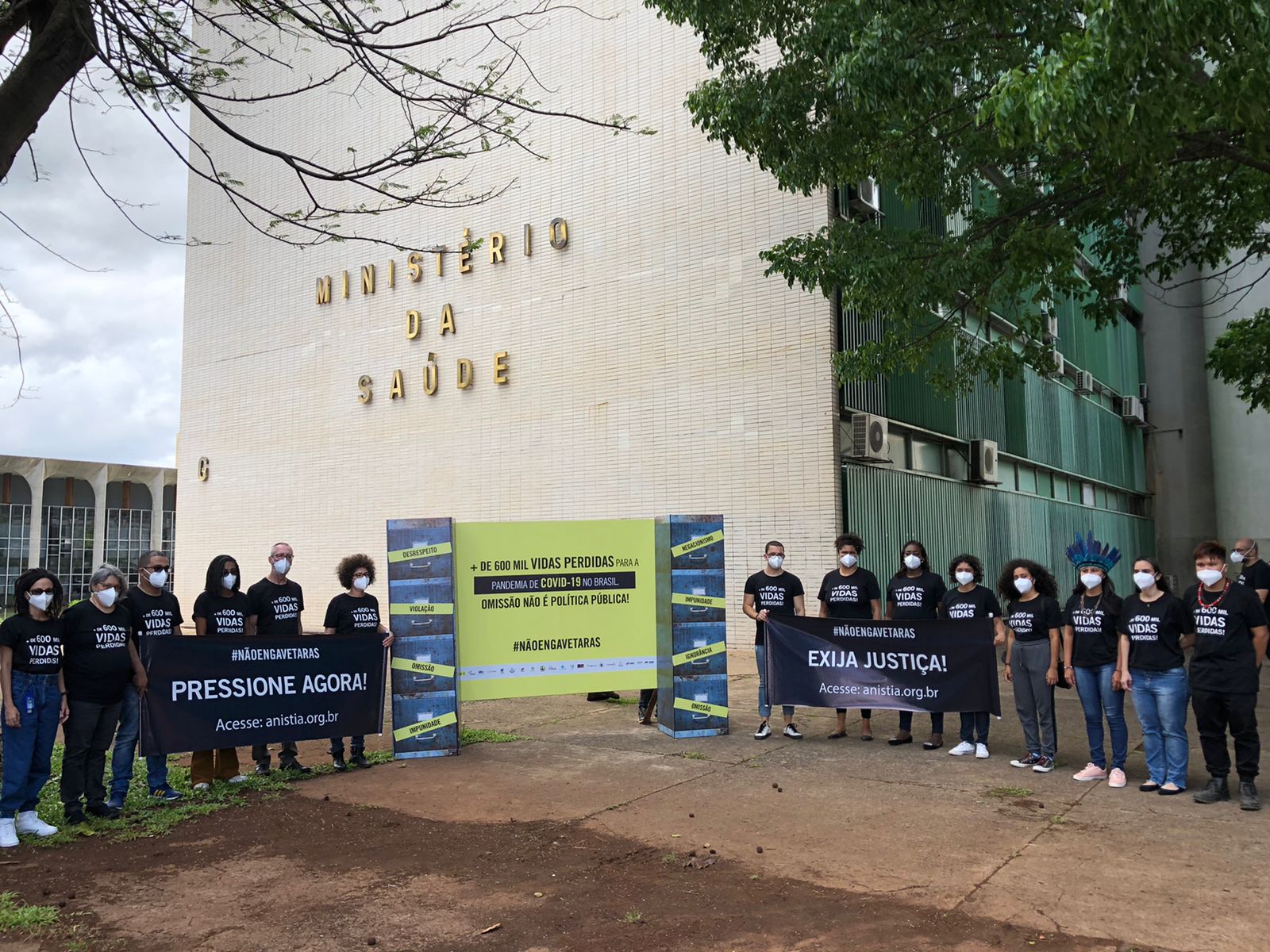 Fotografia mostra pessoas protestando em frente ao Ministério da Saúde com cartazes que cobram responsabilização do governo brasileiro pela má gestão da pandemia de Covid-19/ Foto: Anistia Internacional Brasil  